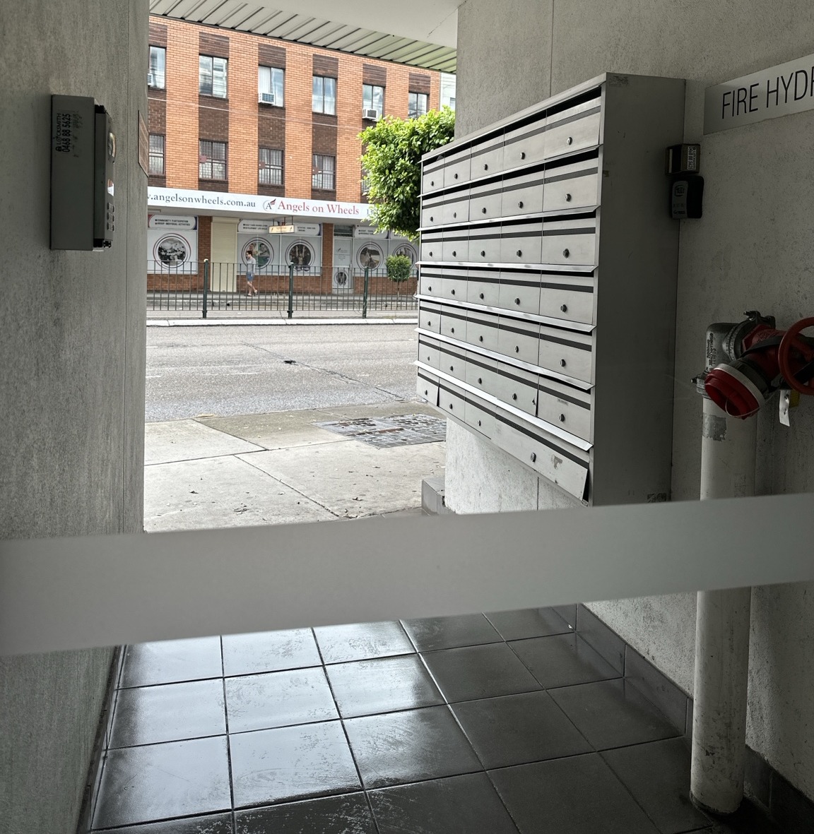 Clean shared building entrance with tiled floors and mailboxes